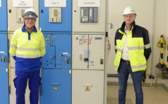 two men standing in front of electrical equipment
