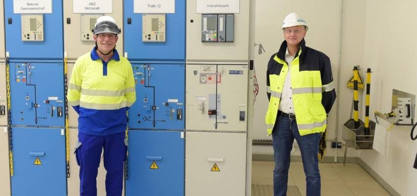 Climate-neutral insulation gas Clean Air replaces fluorine gases two men standing in front of electrical equipment